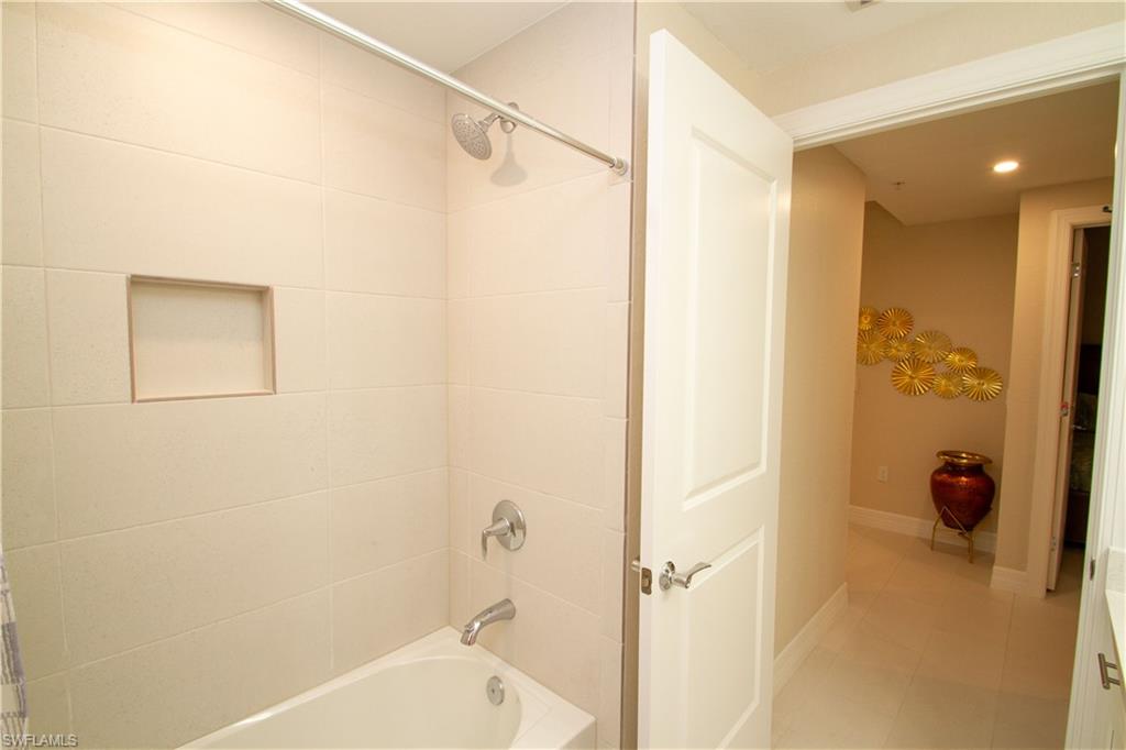 262 Indies Drive East, Unit 101 Naples, FL 34114 - Photo 19 of 32 a bathroom with a tub shower and a sink