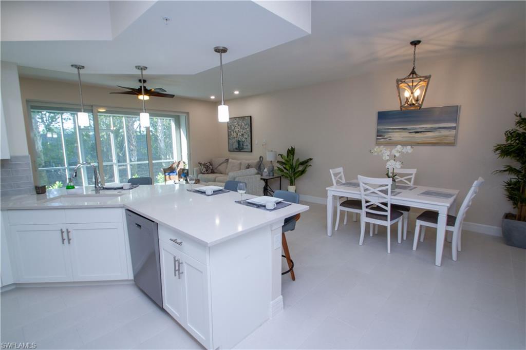 262 Indies Drive East, Unit 101 Naples, FL 34114 - Photo 3 of 32 a kitchen with a table and chairs in it