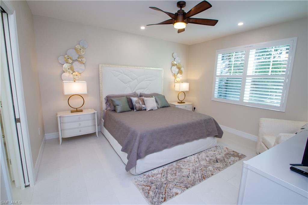 262 Indies Drive East, Unit 101 Naples, FL 34114 - Photo 8 of 32 a bedroom with a bed and a window