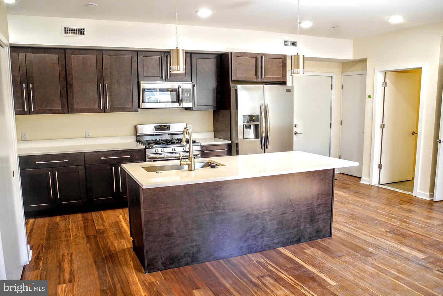 a kitchen with stainless steel appliances a sink stove and refrigerator
