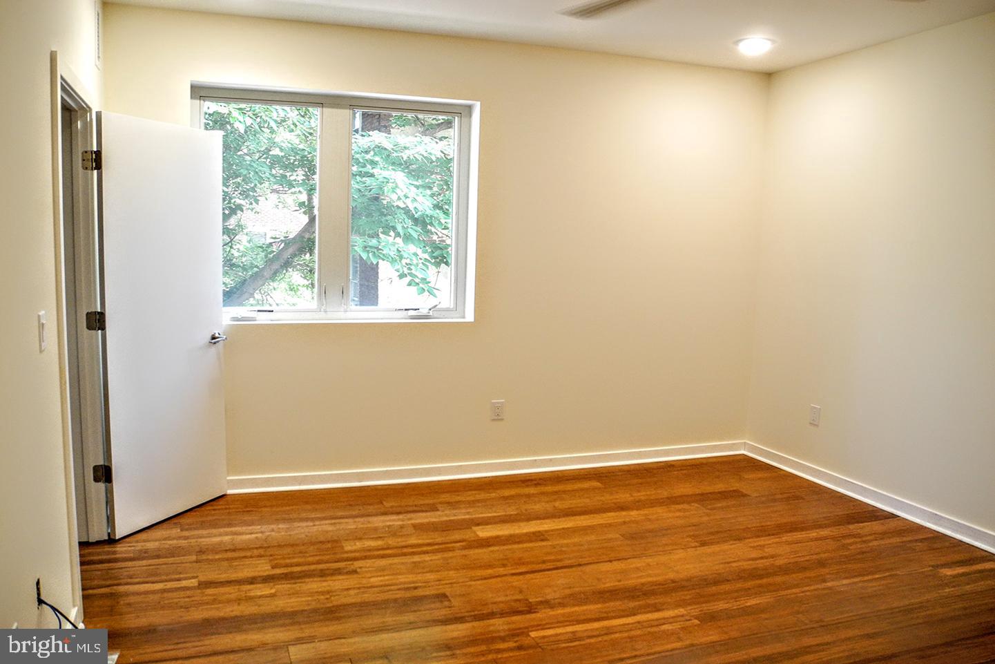 934 South 5th Street, Unit B2 Philadelphia, PA 19147 - Photo 2 of 11 a view of an empty room with wooden floor and a window