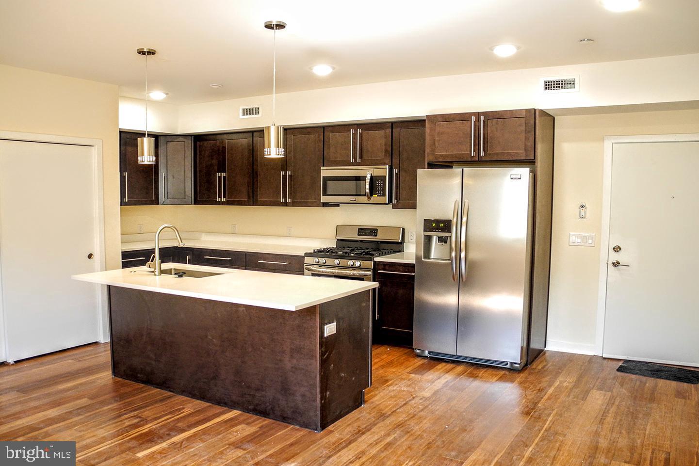 934 South 5th Street, Unit B2 Philadelphia, PA 19147 - Photo 3 of 11 a kitchen with stainless steel appliances granite countertop a refrigerator a sink and a stove
