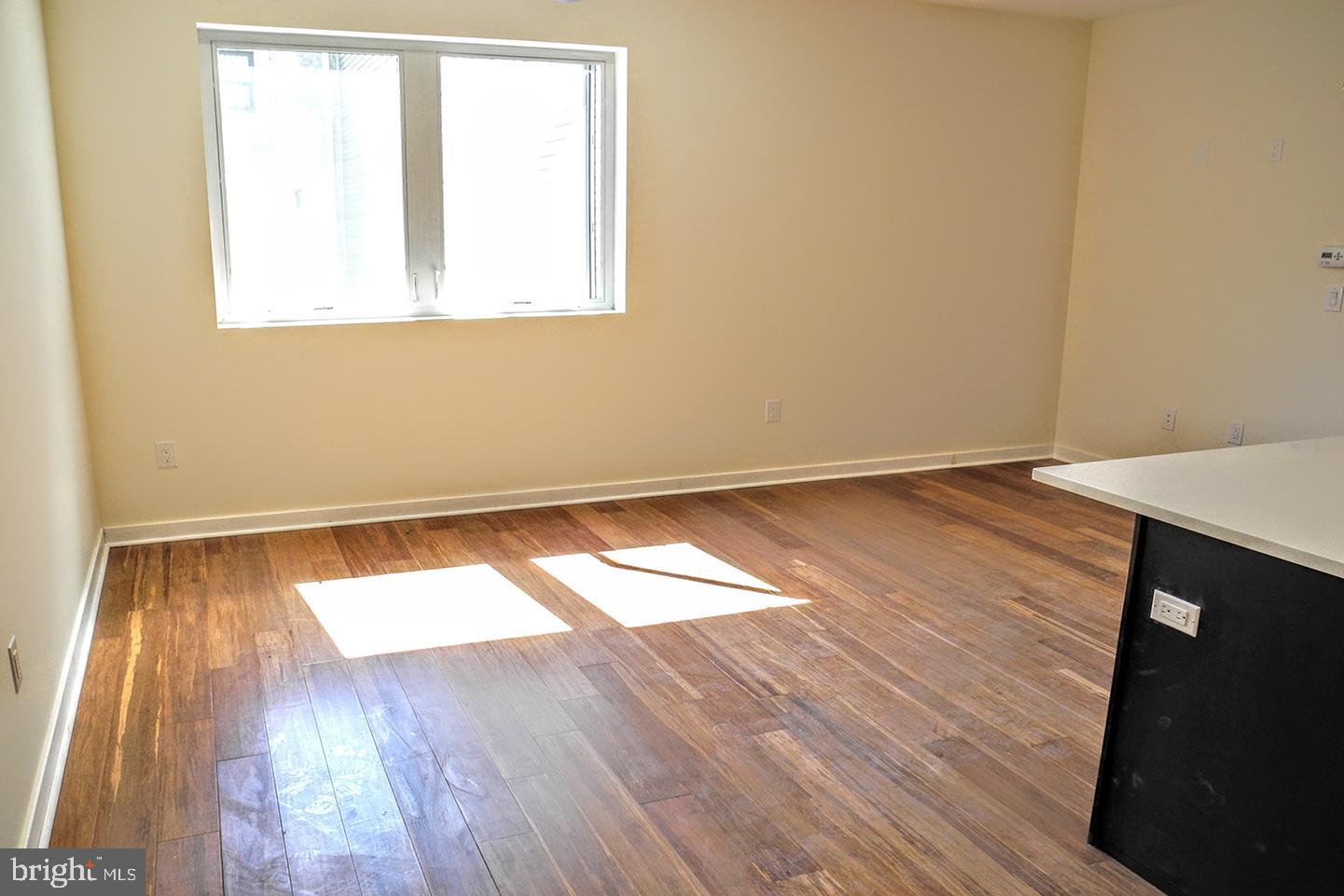 934 South 5th Street, Unit B2 Philadelphia, PA 19147 - Photo 6 of 11 an empty room with wooden floor and windows