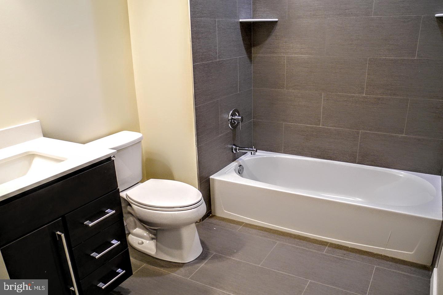 934 South 5th Street, Unit B2 Philadelphia, PA 19147 - Photo 9 of 11 a white toilet sitting next to a white tub