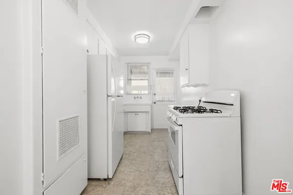 a kitchen with white cabinets and white appliances