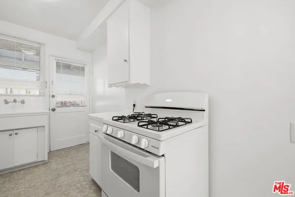 a white stove top oven sitting inside of a kitchen