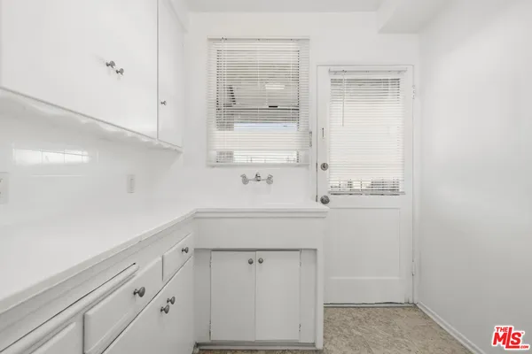a kitchen with white cabinets and white appliances