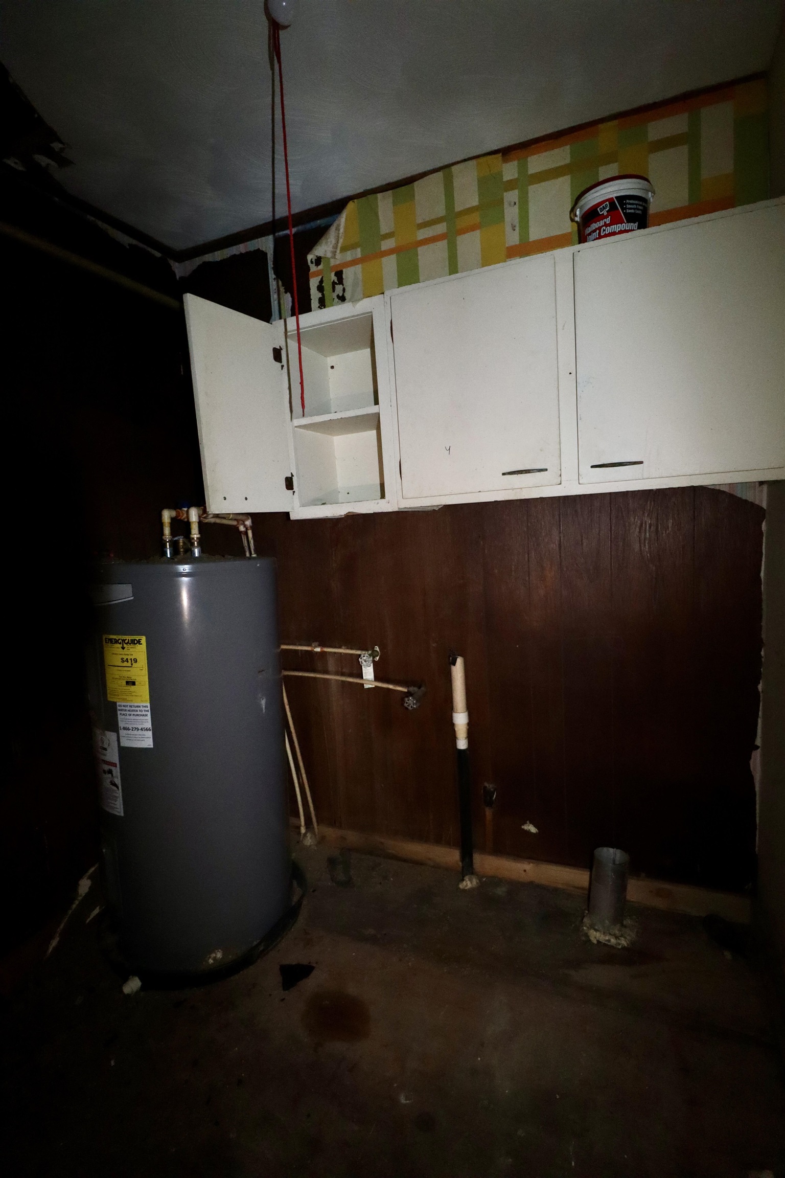 224 Kellar Avenue Ripley, TN 38063 - Photo 19 of 26 a room with water heater and wooden cabinets