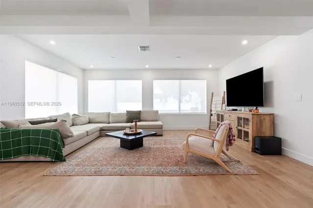 a living room with furniture and a wooden floor