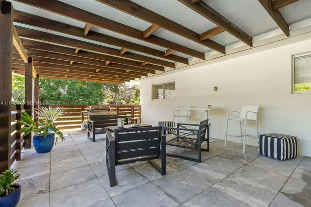a view of a chairs and table in the back yard of the house