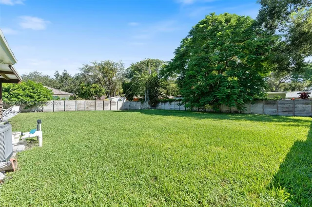 a view of yard with swimming pool and green space