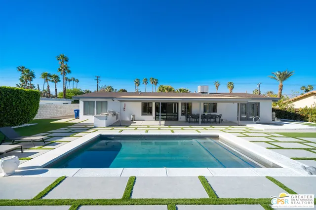 a view of a patio with a table chairs and a floor to ceiling window