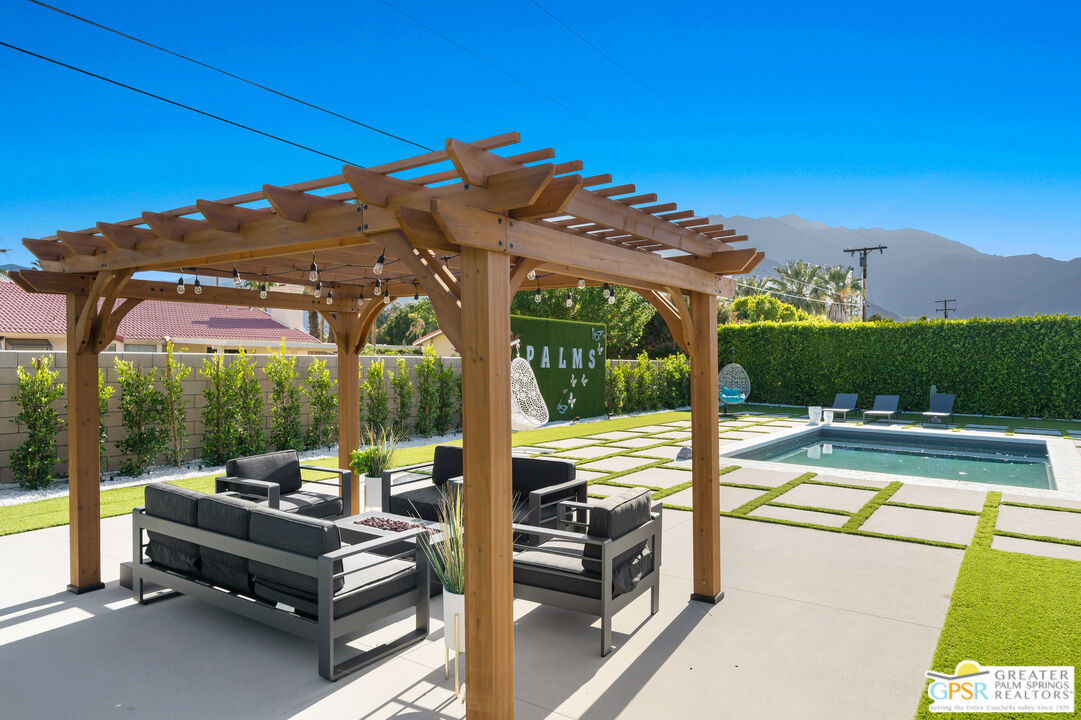 2775 East Verona Road Palm Springs, CA 92262 - Photo 22 of 73 a view of a patio with a table chairs and a floor to ceiling window