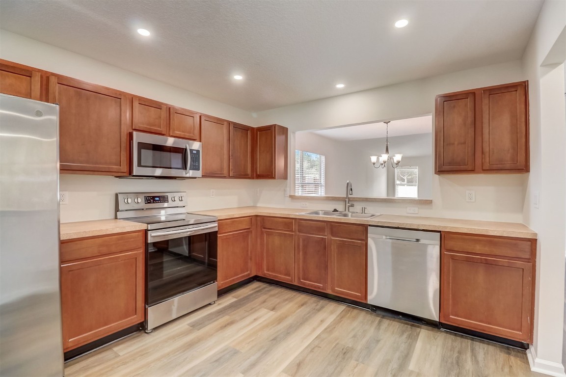 96099 Starlight Lane Yulee, FL 32097 - Photo 11 of 36 a kitchen with stainless steel appliances granite countertop wooden cabinets a stove a sink and a microwave