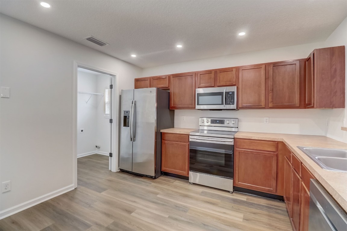 96099 Starlight Lane Yulee, FL 32097 - Photo 8 of 36 a kitchen with stainless steel appliances granite countertop a refrigerator stove and sink
