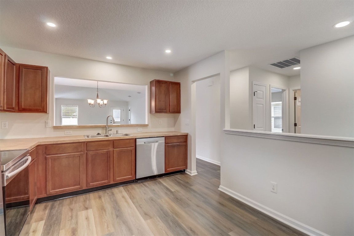 96099 Starlight Lane Yulee, FL 32097 - Photo 9 of 36 a large kitchen with stainless steel appliances granite countertop a lot of counter space and wooden floor