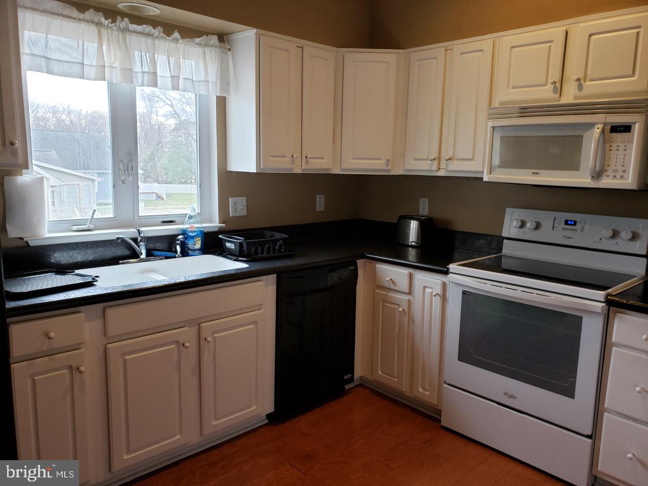 13 Pecan Court, Unit 67G Lewes, DE 19958 - Photo 24 of 25 a kitchen with granite countertop white cabinets and sink
