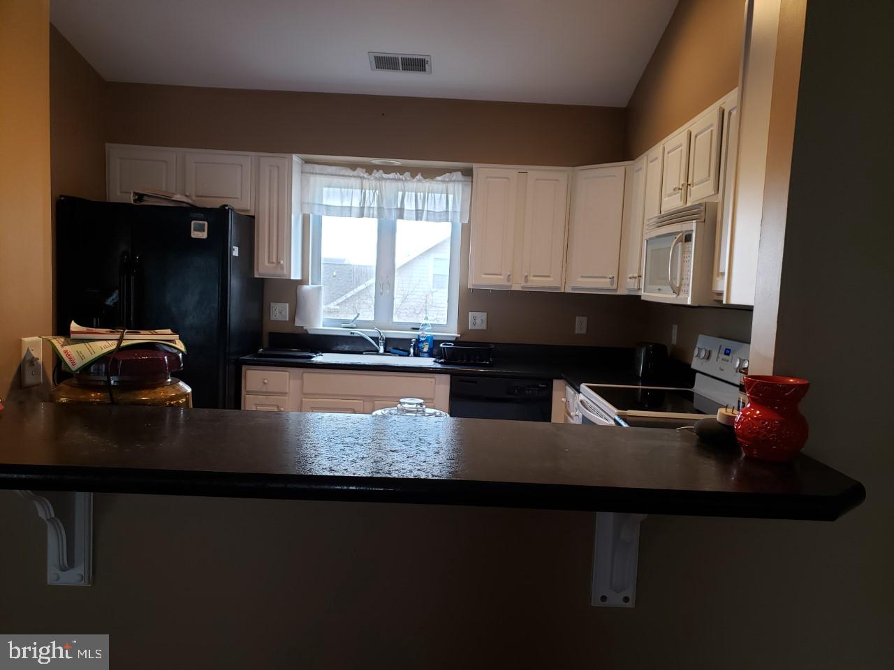 13 Pecan Court, Unit 67G Lewes, DE 19958 - Photo 4 of 25 a kitchen with granite countertop a sink stove and cabinets