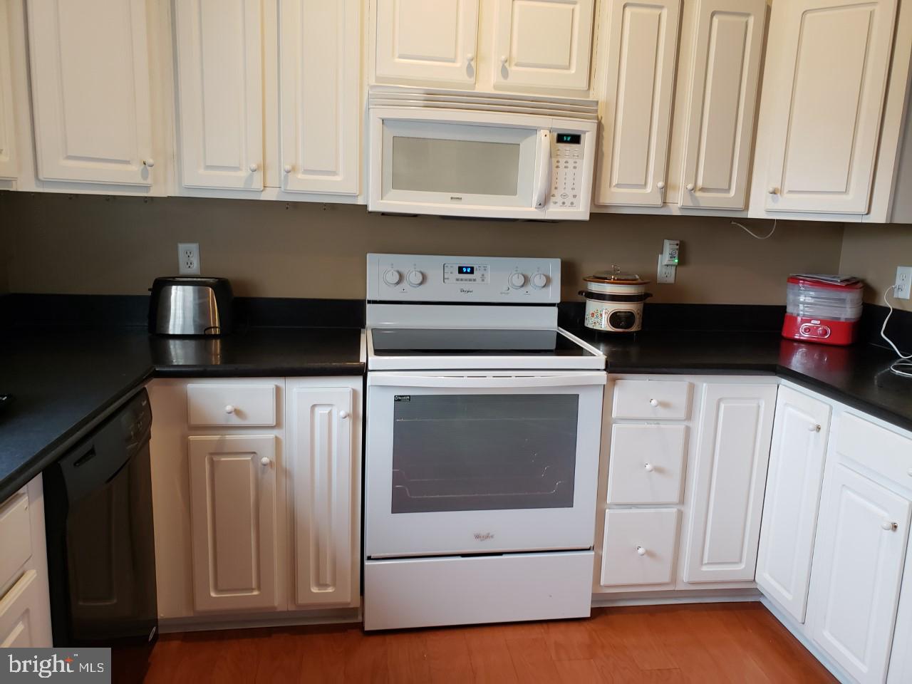 13 Pecan Court, Unit 67G Lewes, DE 19958 - Photo 5 of 25 a kitchen with white cabinets and white appliances