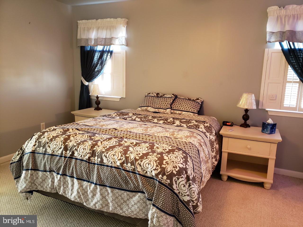 13 Pecan Court, Unit 67G Lewes, DE 19958 - Photo 9 of 25 a bedroom with a bed a mirror and lamp