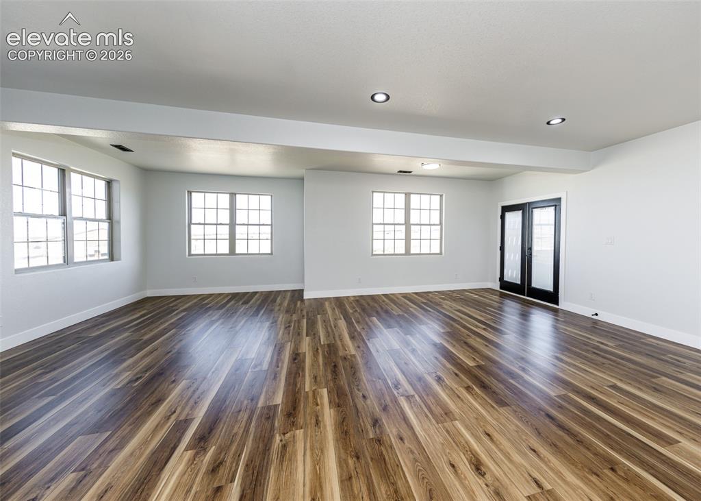 1120 Newton Road Pueblo, CO 81005 - Photo 23 of 46 an empty room with wooden floor and windows