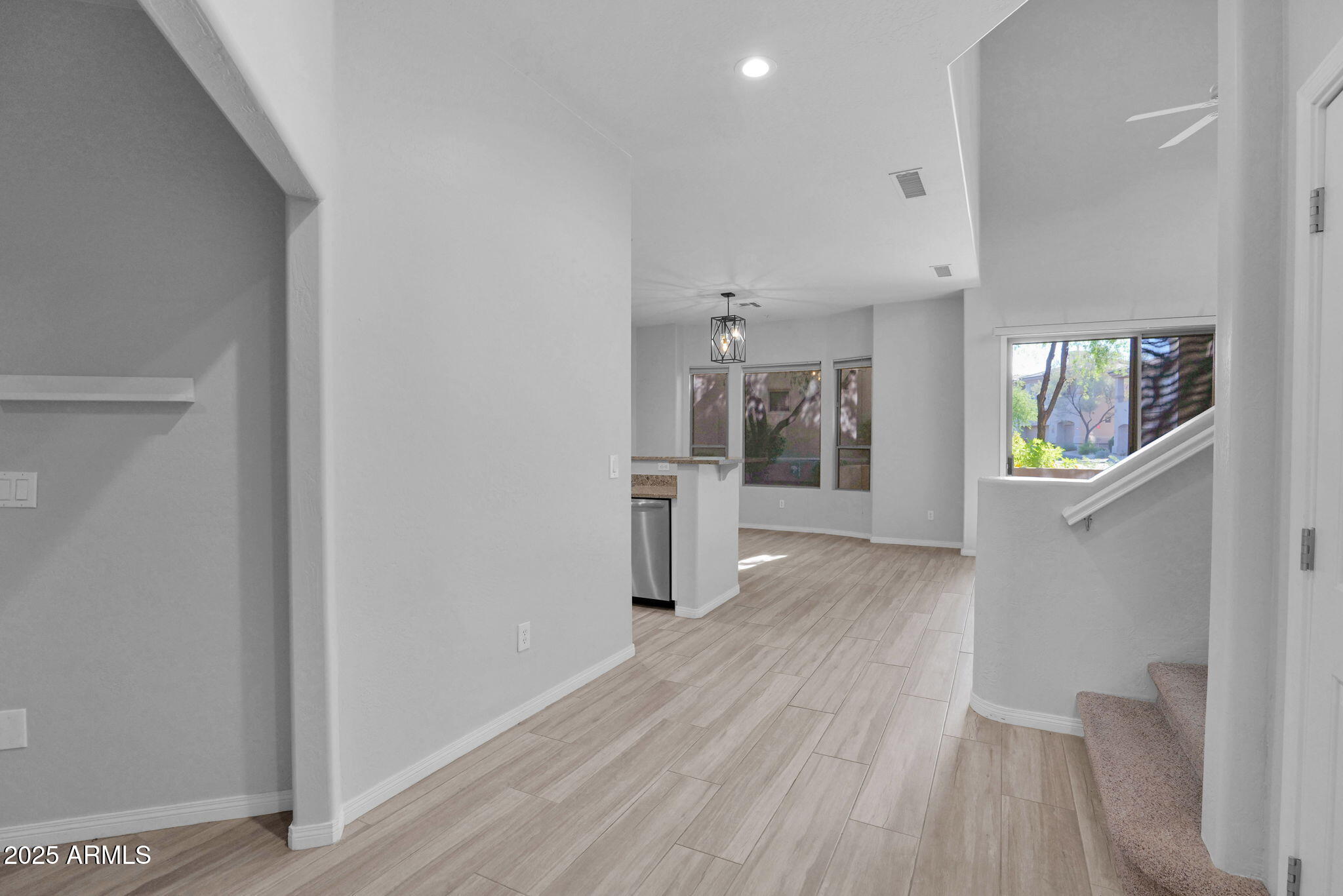 16420 North Thompson Peak Parkway, Unit 1057 Scottsdale, AZ 85260 - Photo 11 of 39 a view of a kitchen and an empty room with wooden floor and a kitchen