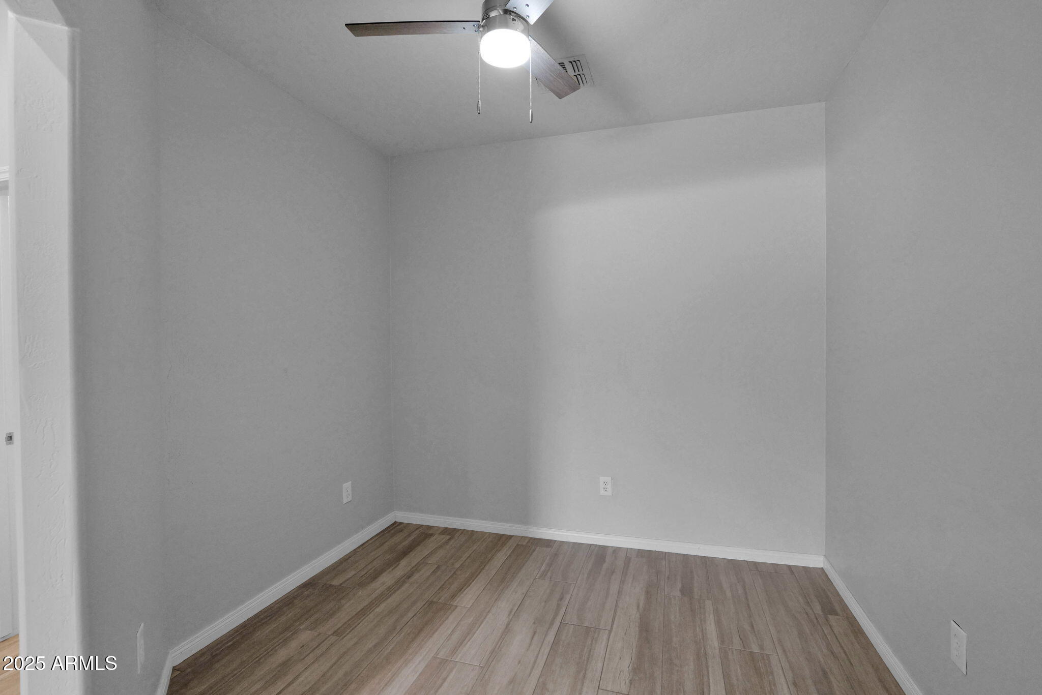 16420 North Thompson Peak Parkway, Unit 1057 Scottsdale, AZ 85260 - Photo 12 of 39 a view of an empty room with wooden floor