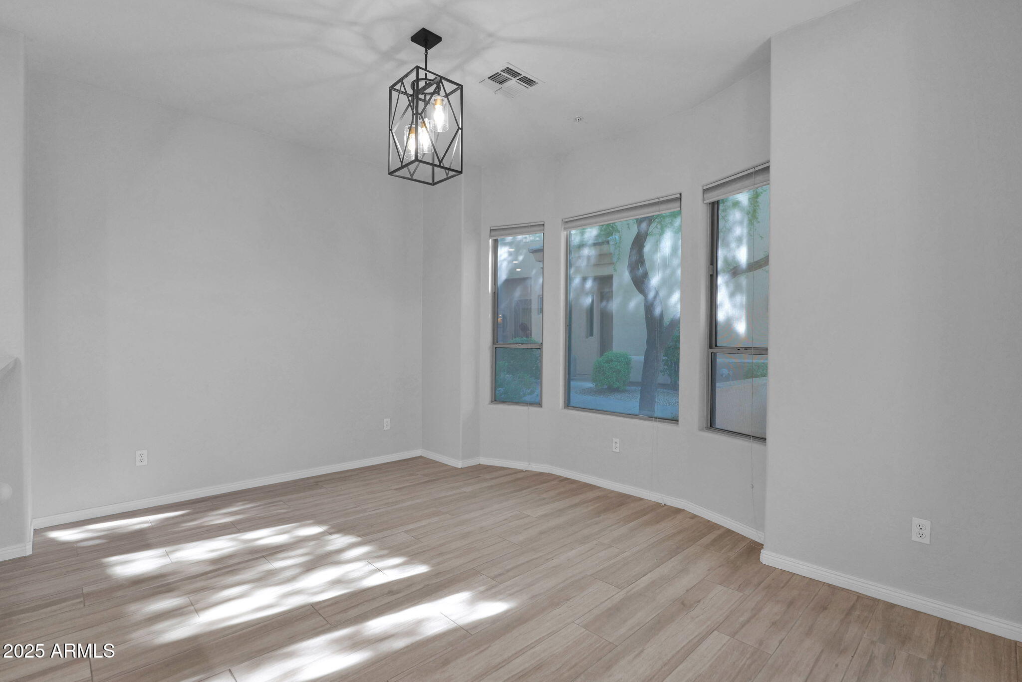 16420 North Thompson Peak Parkway, Unit 1057 Scottsdale, AZ 85260 - Photo 2 of 39 a view of an empty room with wooden floor and a window