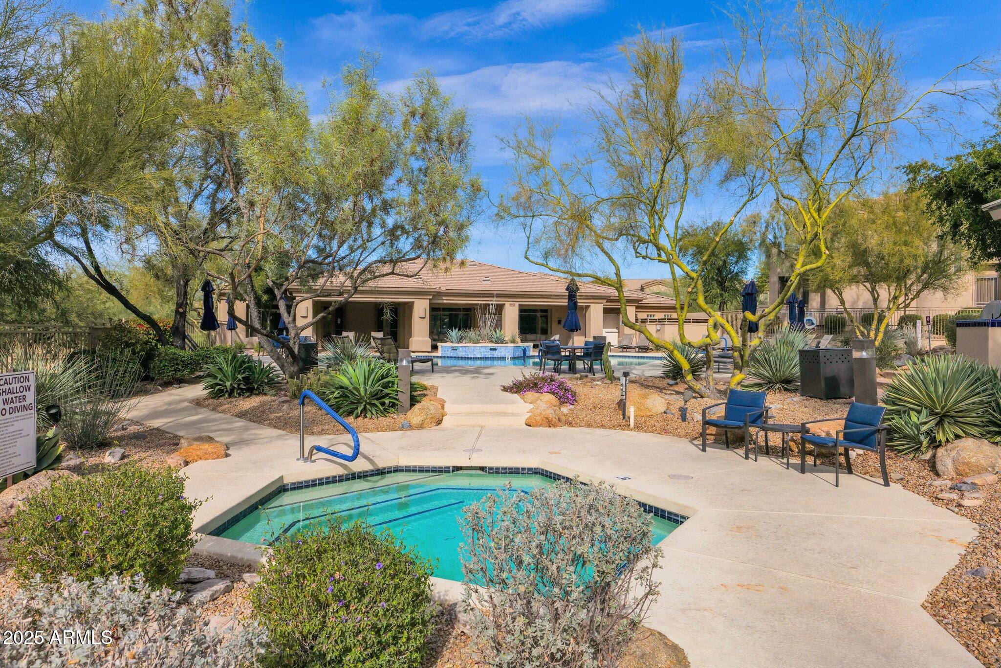 16420 North Thompson Peak Parkway, Unit 1057 Scottsdale, AZ 85260 - Photo 30 of 39 a view of a swimming pool with lawn chairs under an umbrella