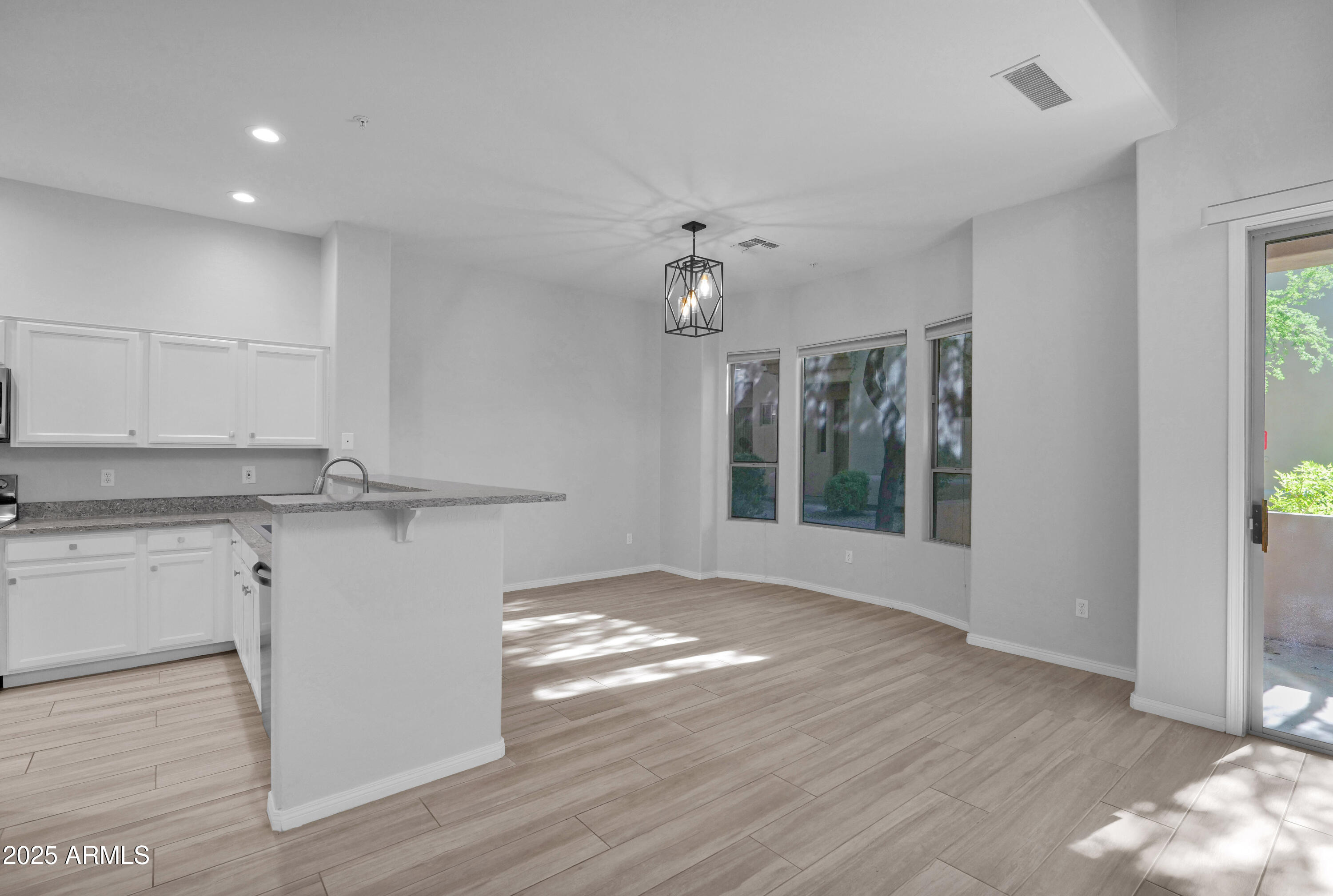 16420 North Thompson Peak Parkway, Unit 1057 Scottsdale, AZ 85260 - Photo 3 of 39 a view of kitchen with granite countertop cabinets and wooden floor