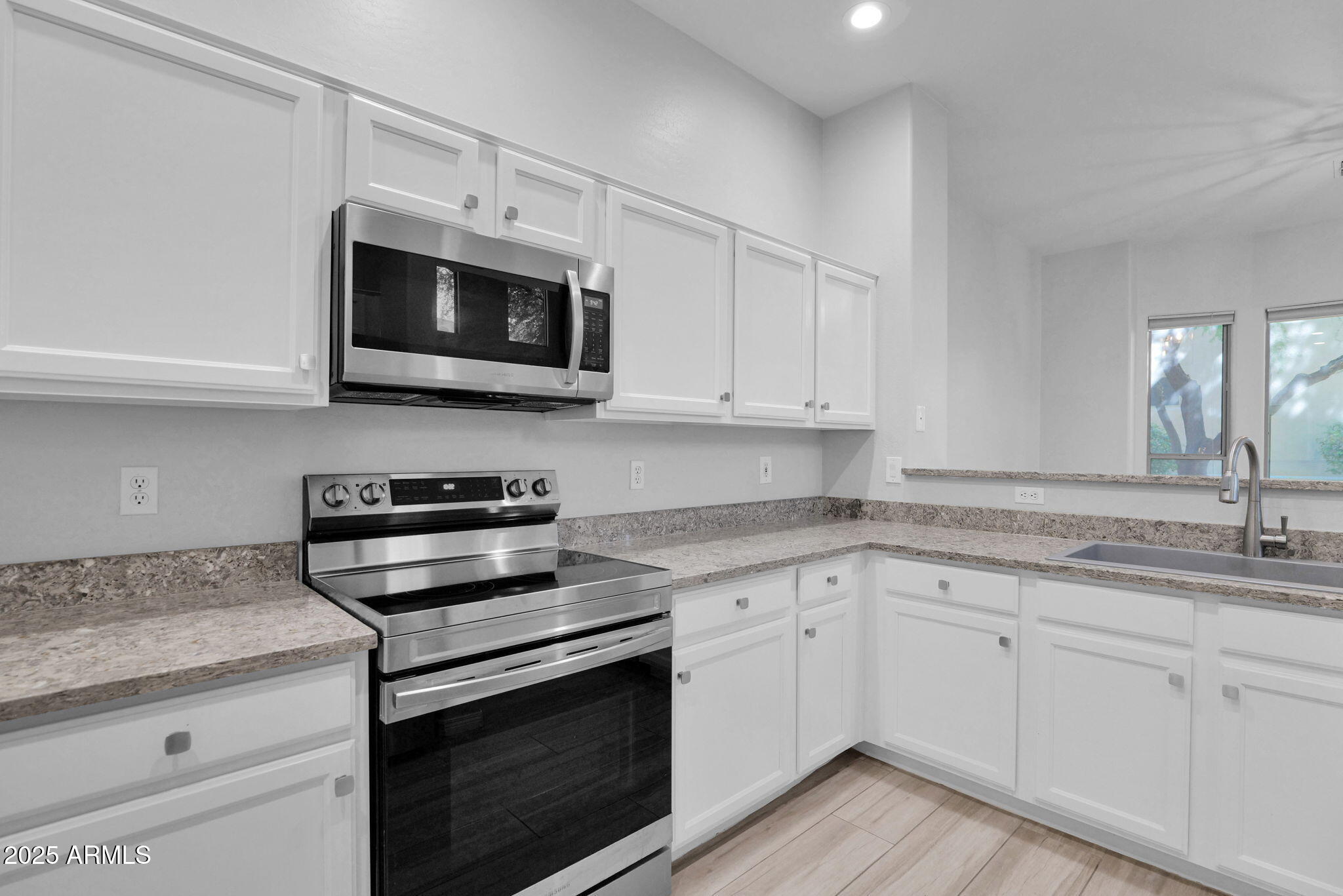 16420 North Thompson Peak Parkway, Unit 1057 Scottsdale, AZ 85260 - Photo 9 of 39 a kitchen with stainless steel appliances granite countertop grey cabinets a stove a sink and dishwasher