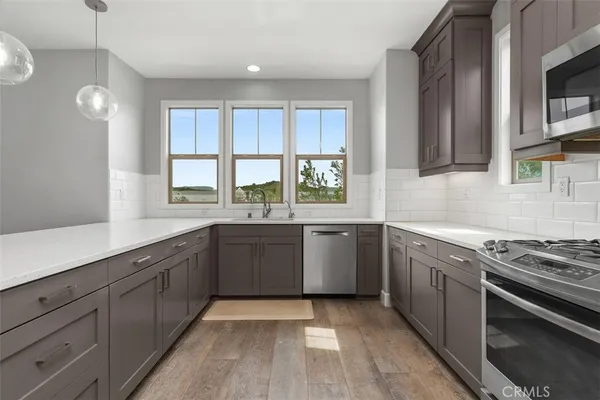 a kitchen with stainless steel appliances granite countertop a stove a sink and a microwave