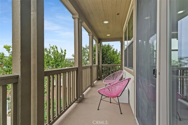 a view of a balcony with chair and a red gate