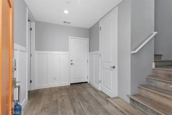 a view of a hallway with wooden floor and entryway