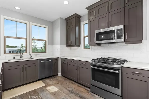 a kitchen with stainless steel appliances granite countertop a stove microwave and sink
