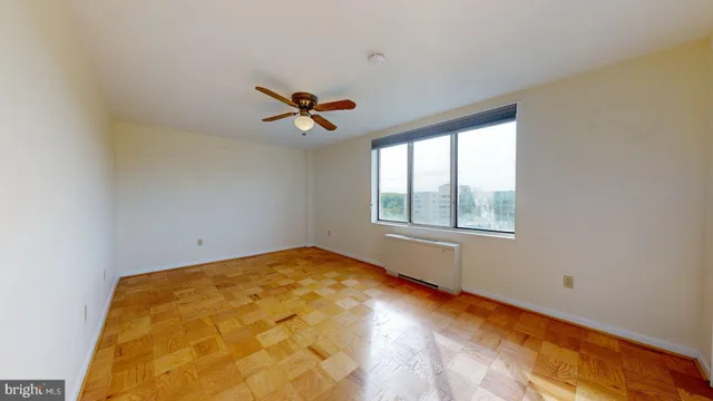 a view of a big room with windows and chandelier fan