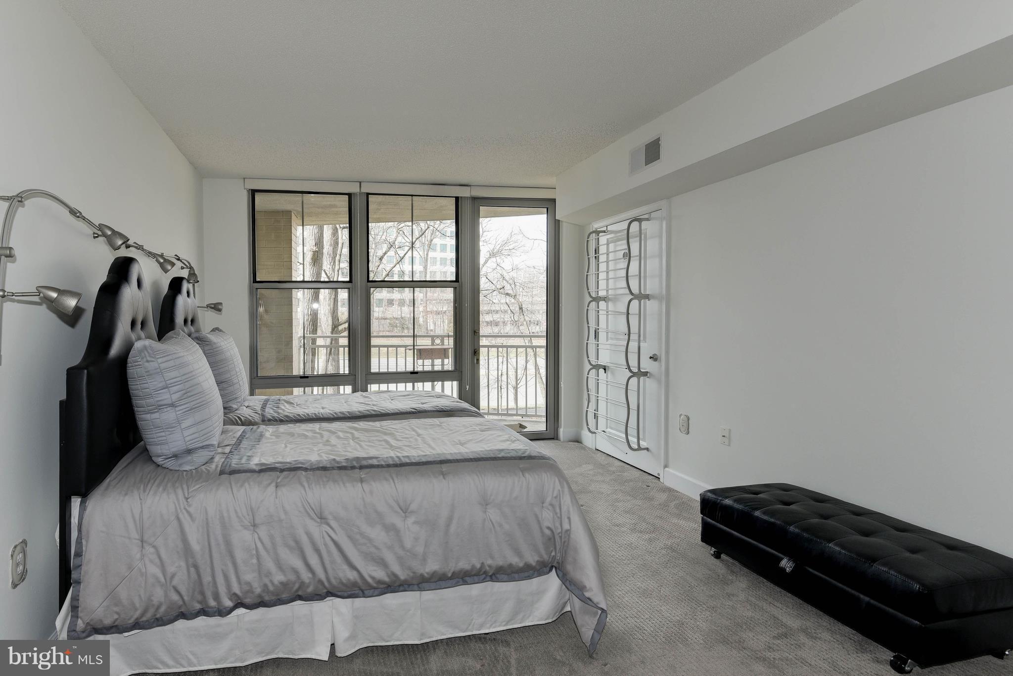 11800 Sunset Hills Road, Unit 314 Reston, VA 20190 - Photo 13 of 30 a bedroom with a bed a couch and a window