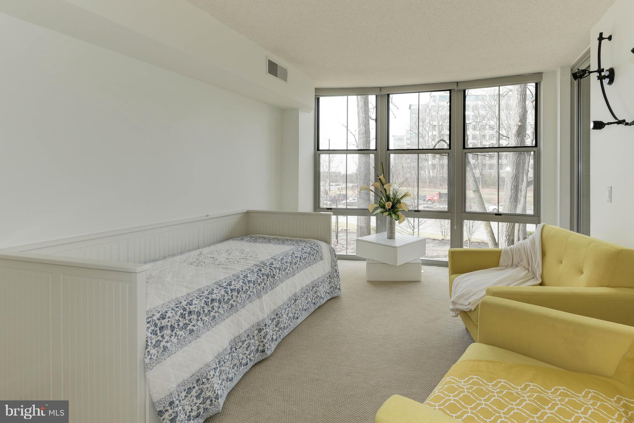 11800 Sunset Hills Road, Unit 314 Reston, VA 20190 - Photo 14 of 30 a spacious bedroom with a bed and glass windows