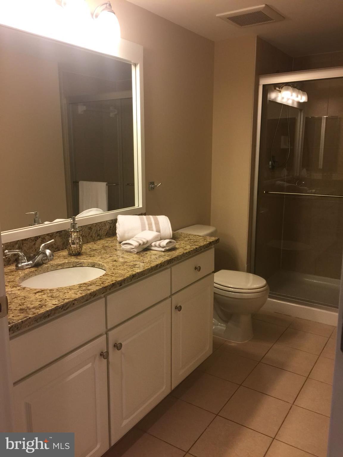 11800 Sunset Hills Road, Unit 314 Reston, VA 20190 - Photo 49 of 53 a bathroom with a granite countertop sink toilet and shower