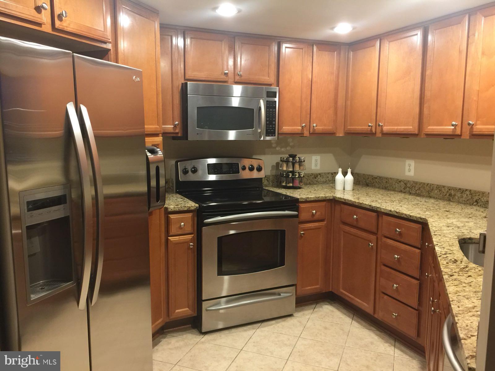 11800 Sunset Hills Road, Unit 314 Reston, VA 20190 - Photo 7 of 30 a kitchen with stainless steel appliances granite countertop a refrigerator a stove and a sink