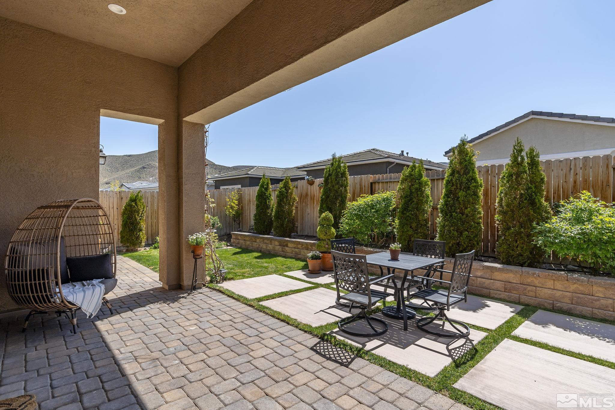 2460 Buttermere Court Reno, NV 89521 - Photo 14 of 22 a view of a patio with table and chairs potted plants and palm tree