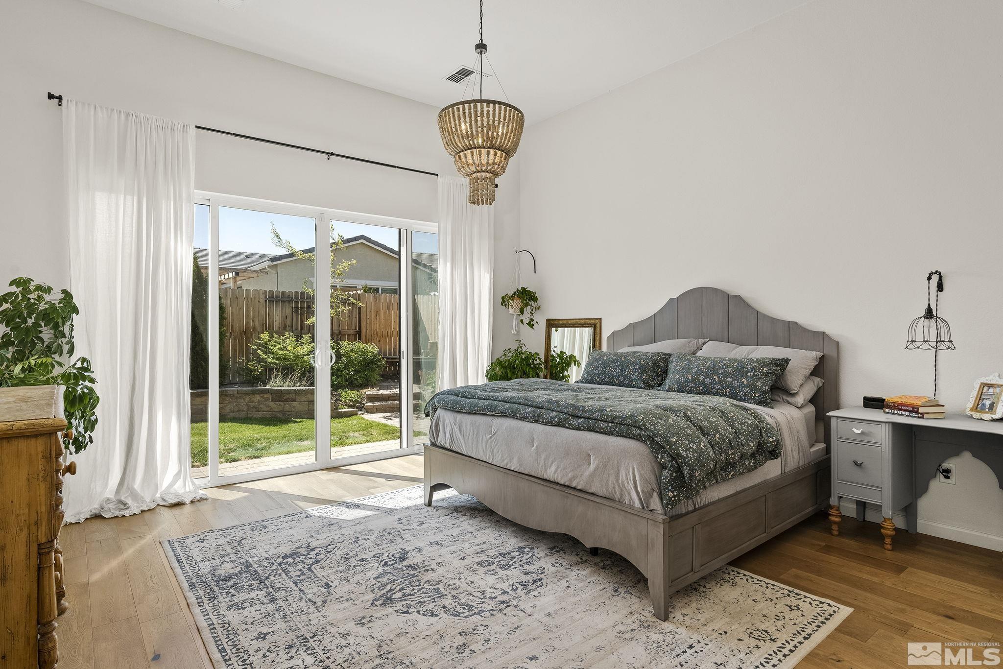 2460 Buttermere Court Reno, NV 89521 - Photo 6 of 22 a spacious bedroom with a bed a window and a chandelier
