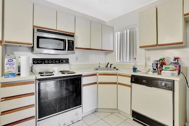 a kitchen with stainless steel appliances granite countertop white cabinets a sink and a stove