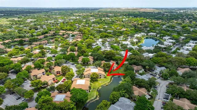 an aerial view of residential houses with outdoor space and trees