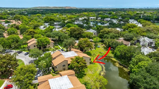 an aerial view of residential houses with outdoor space and trees