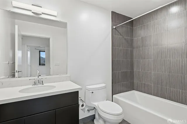 a bathroom with a toilet a sink and mirror