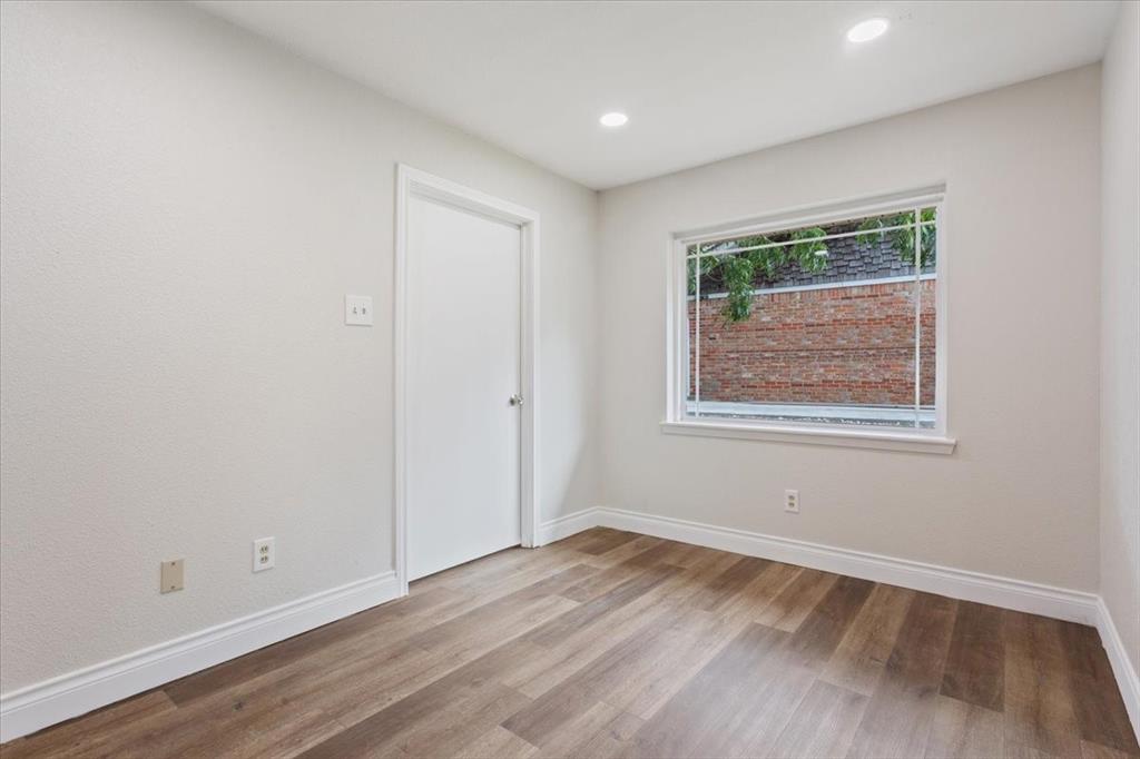 849 Arlington Drive Woodway, TX 76712 - Photo 11 of 33 an empty room with wooden floor and windows