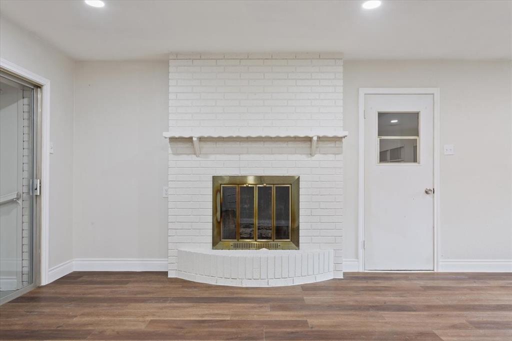849 Arlington Drive Woodway, TX 76712 - Photo 13 of 33 a view of an empty room with wooden floor and a fireplace