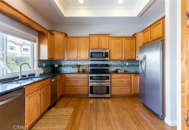 a kitchen with stainless steel appliances granite countertop a refrigerator a sink dishwasher a stove and a microwave oven