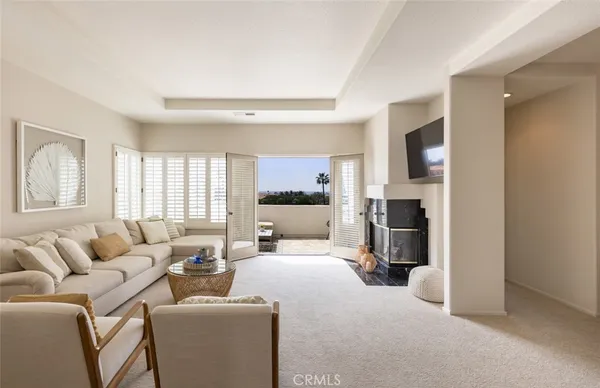 a living room with furniture a large window and a fireplace